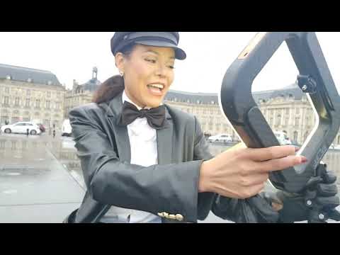 “Rainy day, bold outfit ☔🖤 Bow tie, gloves, tights, boots — timeless style meets iconic background.”