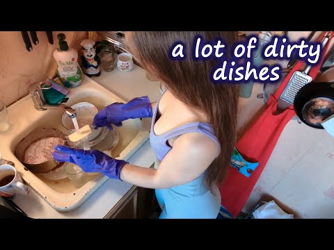 Washing dishes with purple rubber gloves
