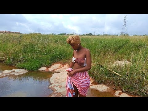 Village girl washing dishes in the River(or bath?) Africa